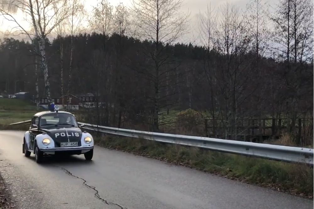 Polisbubbla ute på landsväg i höstlandskap.